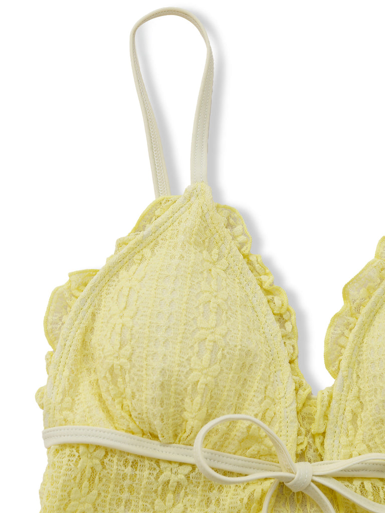 Yellow textured bikini top with thin straps on a white background