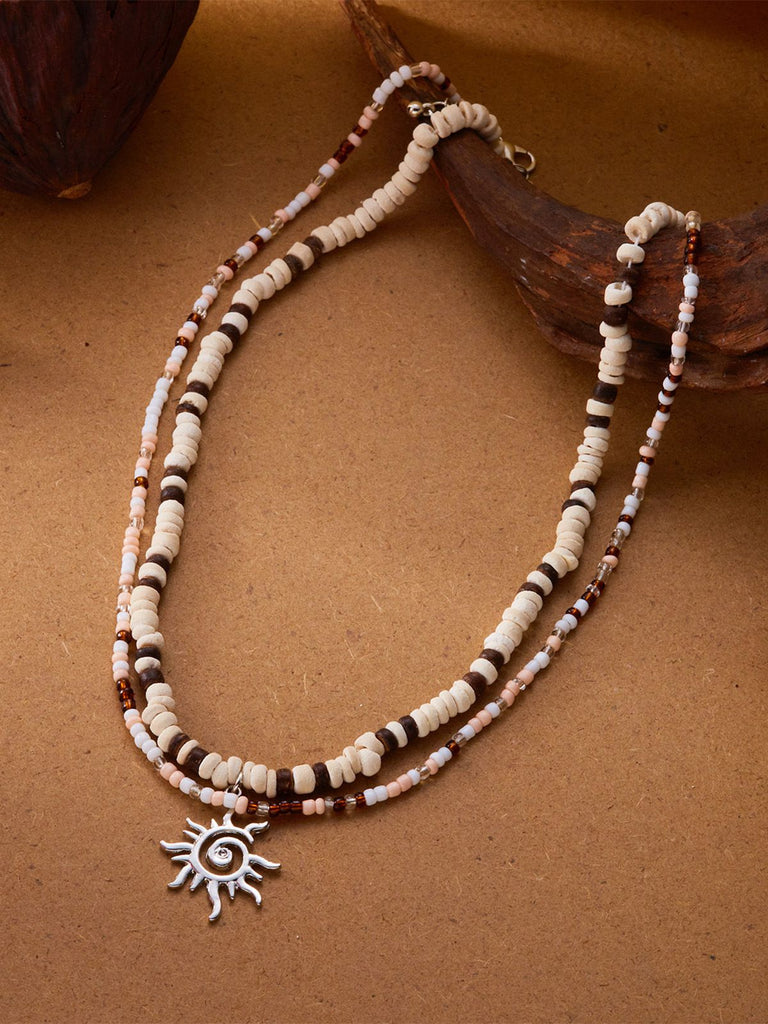Collier plusieurs rangs pendentif soleil perles blanches et brunes