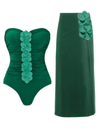 Green strapless swimsuit with floral details and matching green skirt on a white background