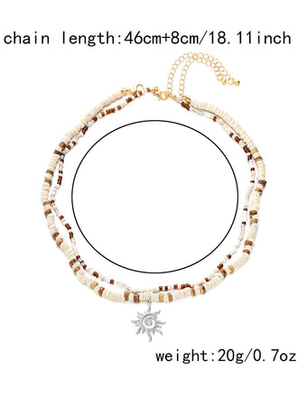 Collier plusieurs rangs pendentif soleil perles blanches et brunes