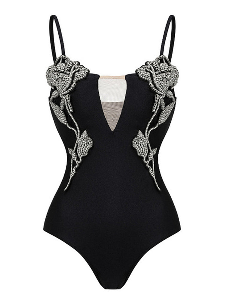 Black swimsuit with floral embellishments on a white background