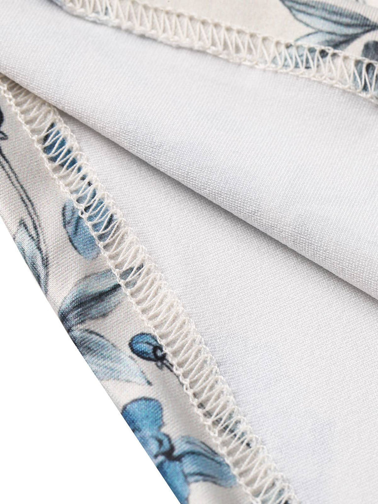 Close-up of fabric with blue floral pattern and white lace trim on a light gray background