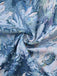 Close-up of textured fabric with floral pattern in blue, white, and pink.