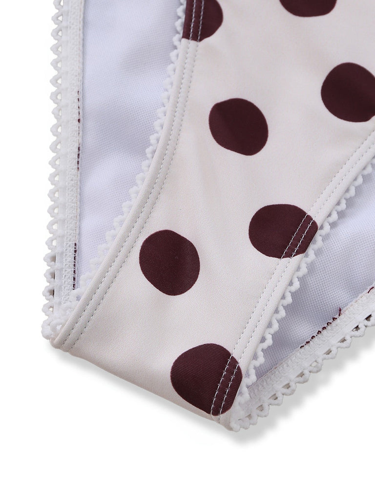 White fabric with brown polka dots and lace trim on a white background