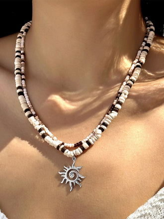 Collier plusieurs rangs pendentif soleil perles blanches et brunes