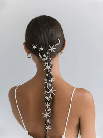 Femme aux cheveux finement coiffés, ornés de motifs d'étoiles de mer et de lunes sur fond uni