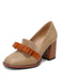 Chaussure beige avec un nœud marron et un talon bloc sur fond blanc