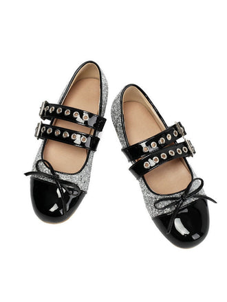 Pair of black and silver glittery shoes with patent leather accents on a white background