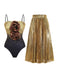 Gold and black swimsuit with floral details and a gold pleated skirt on a white background