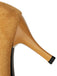 Close-up of a tan high-heeled shoe with textured heel and black sole on a white background