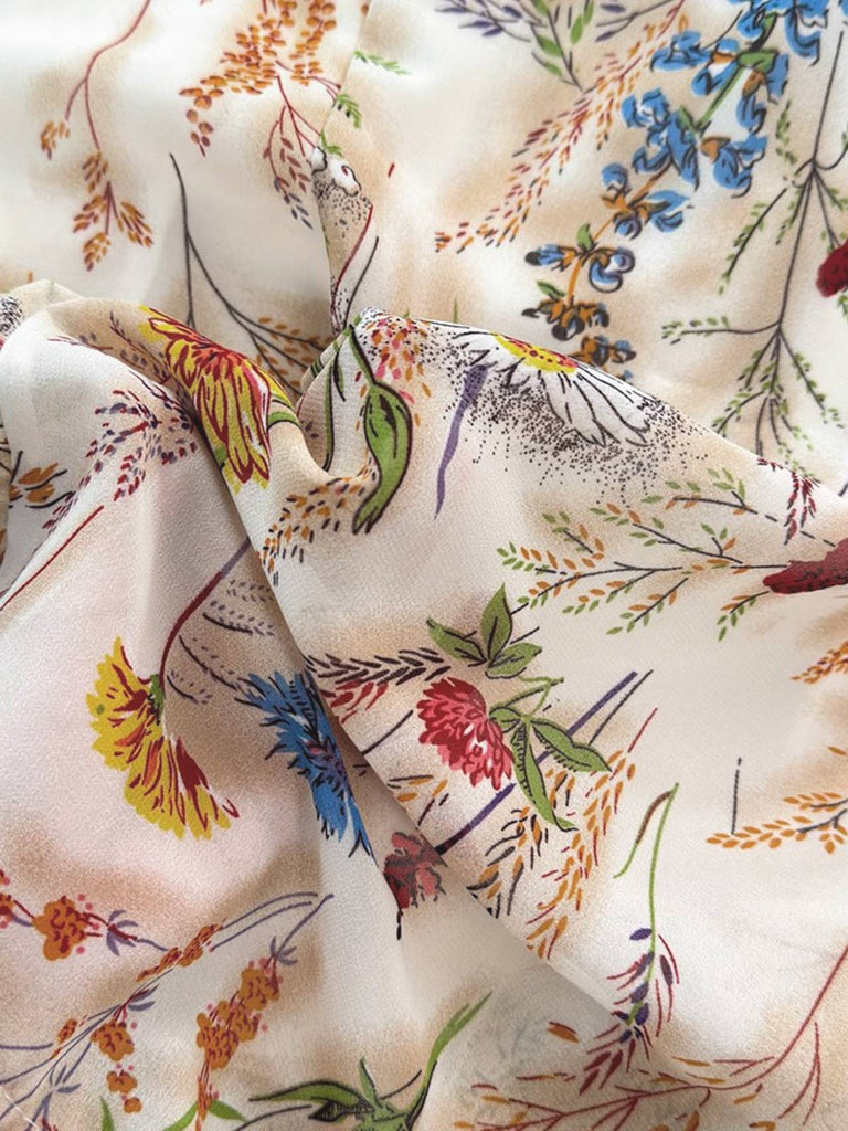 Close-up of floral fabric with colorful flowers and leaves on a beige background