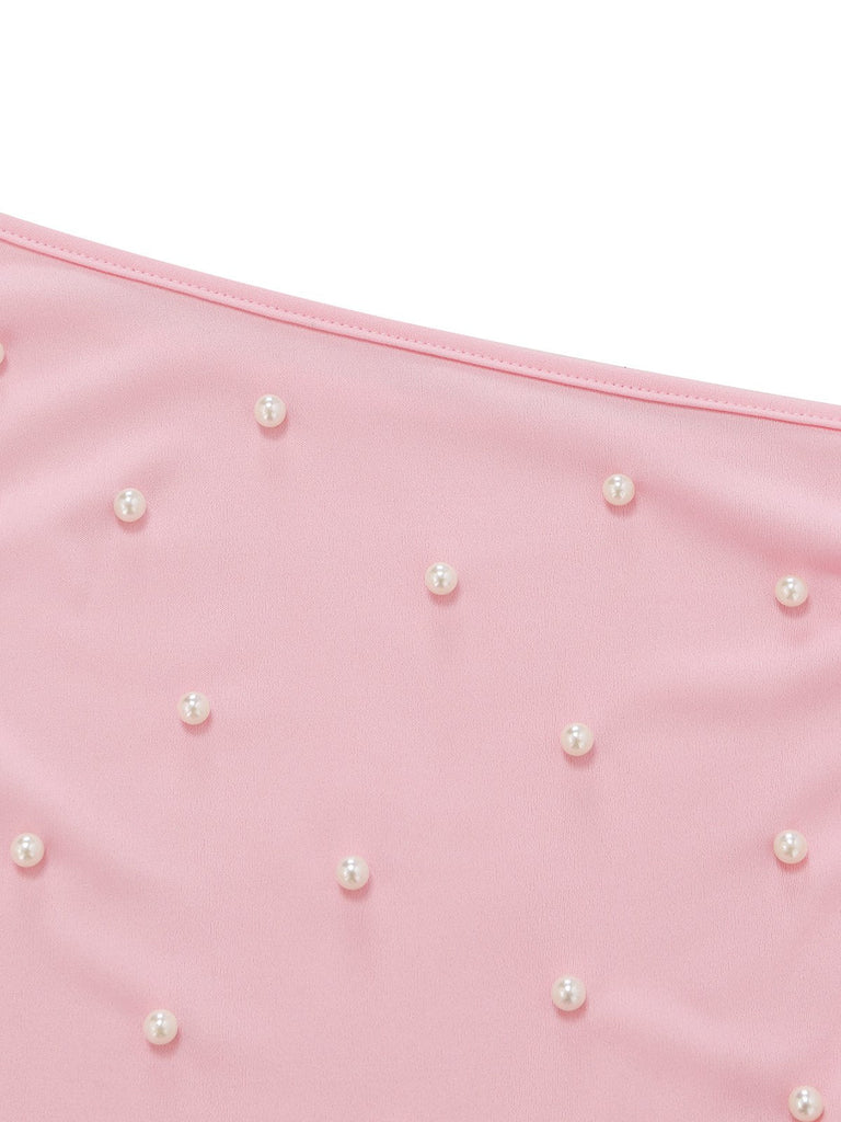 Pink fabric with scattered pearls on a white background