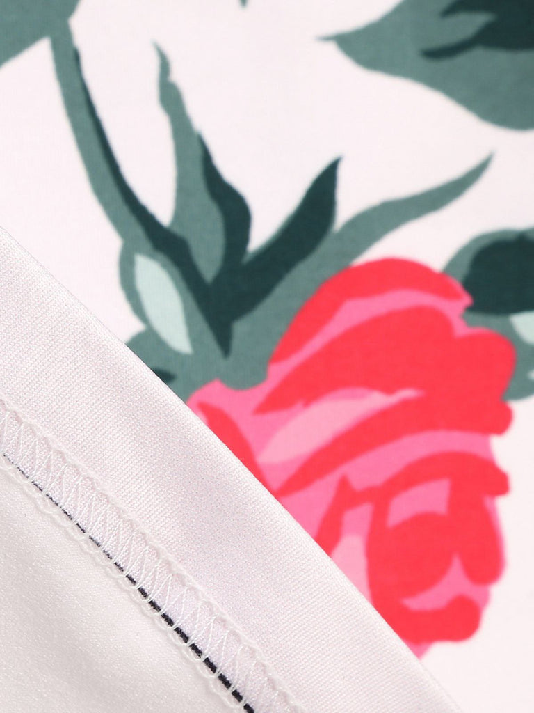 Close-up of a floral pattern with pink rose and green leaves on a white background