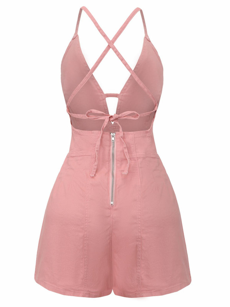 Pink romper with criss-cross straps and zipper on a white background