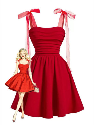 Une robe rouge vif de style vintage, cintrée et évasée, avec des épaules à nouer en ruban transparent et un corsage froncé, ornée d'une illustration de pin-up blonde.