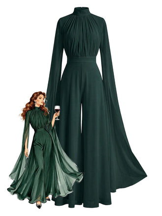 Robe de soirée verte à manches longues et à effet cape, portée par un mannequin tenant un verre de vin.