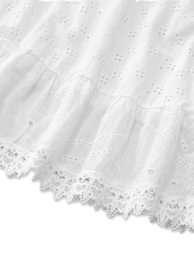Close-up of a white lace-trimmed dress on a white background