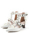 Chaussures blanches à talons hauts ornées de détails et de boucles dorées sur fond blanc
