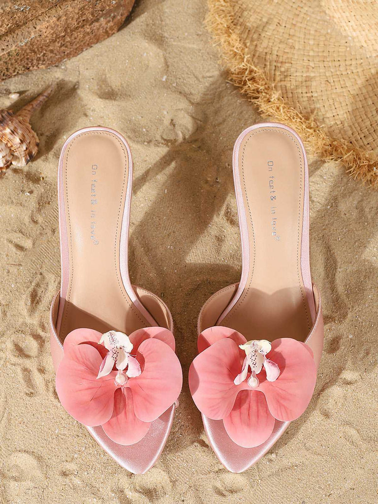 Top-down perspective of the light pink satin mules emphasizing the pointed toe and matching floral detail.