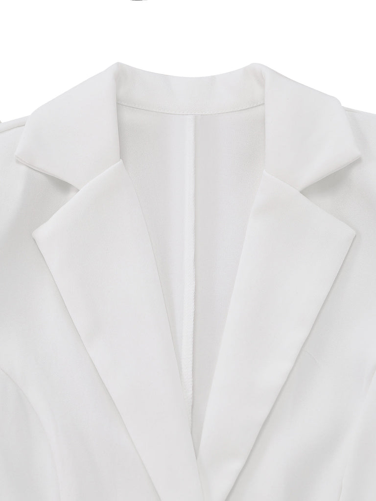 Close-up of the sharp notched lapel and double-button closure on the white blazer dress.