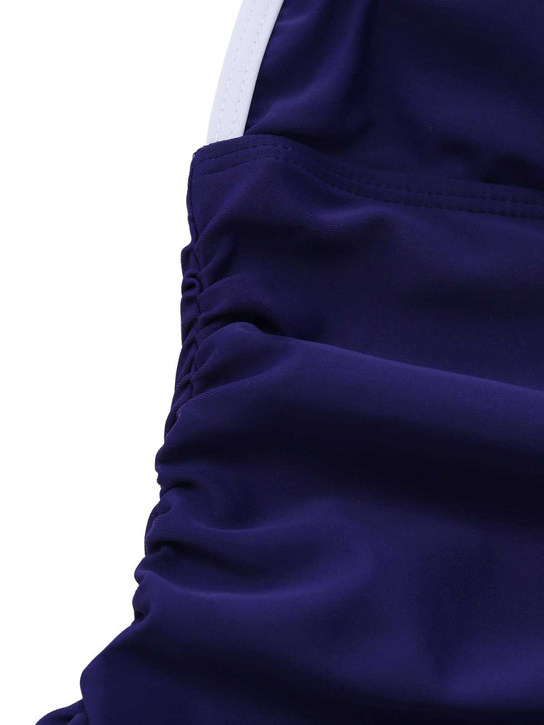 Macro shot of the shirred side panels designed for a slimming tummy-control effect on the one-piece swimsuit.
