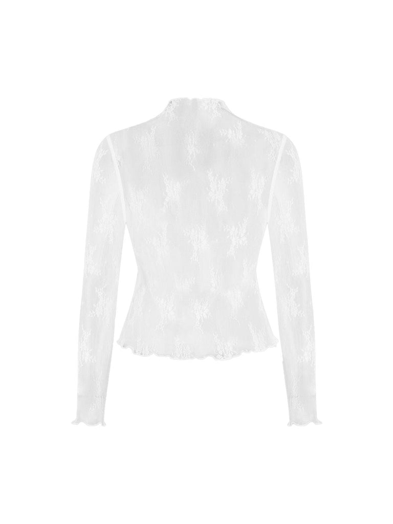 Detailed view of the white floral lace long-sleeve top paired with a black jumpsuit.