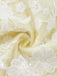 A macro view of the dress fabric showing the detailed texture of the yellow base and white lace overlay.
