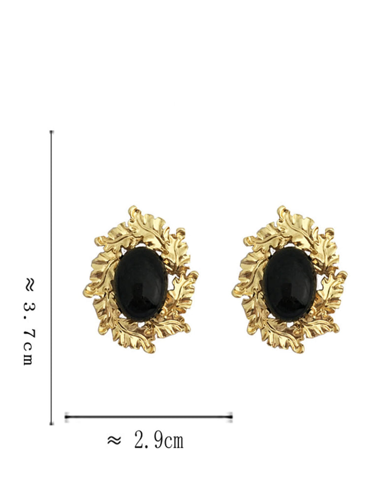 Boucles d'oreilles avec pierres précieuses noires cerclées d'or