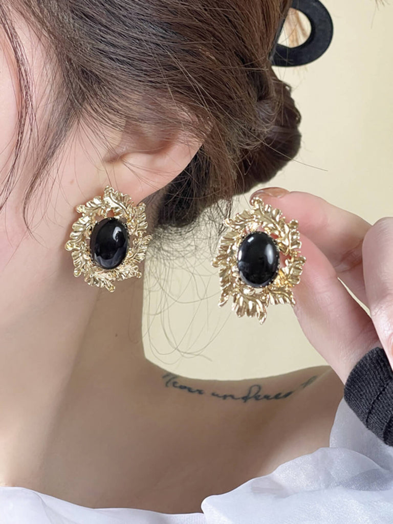 Boucles d'oreilles avec pierres précieuses noires cerclées d'or